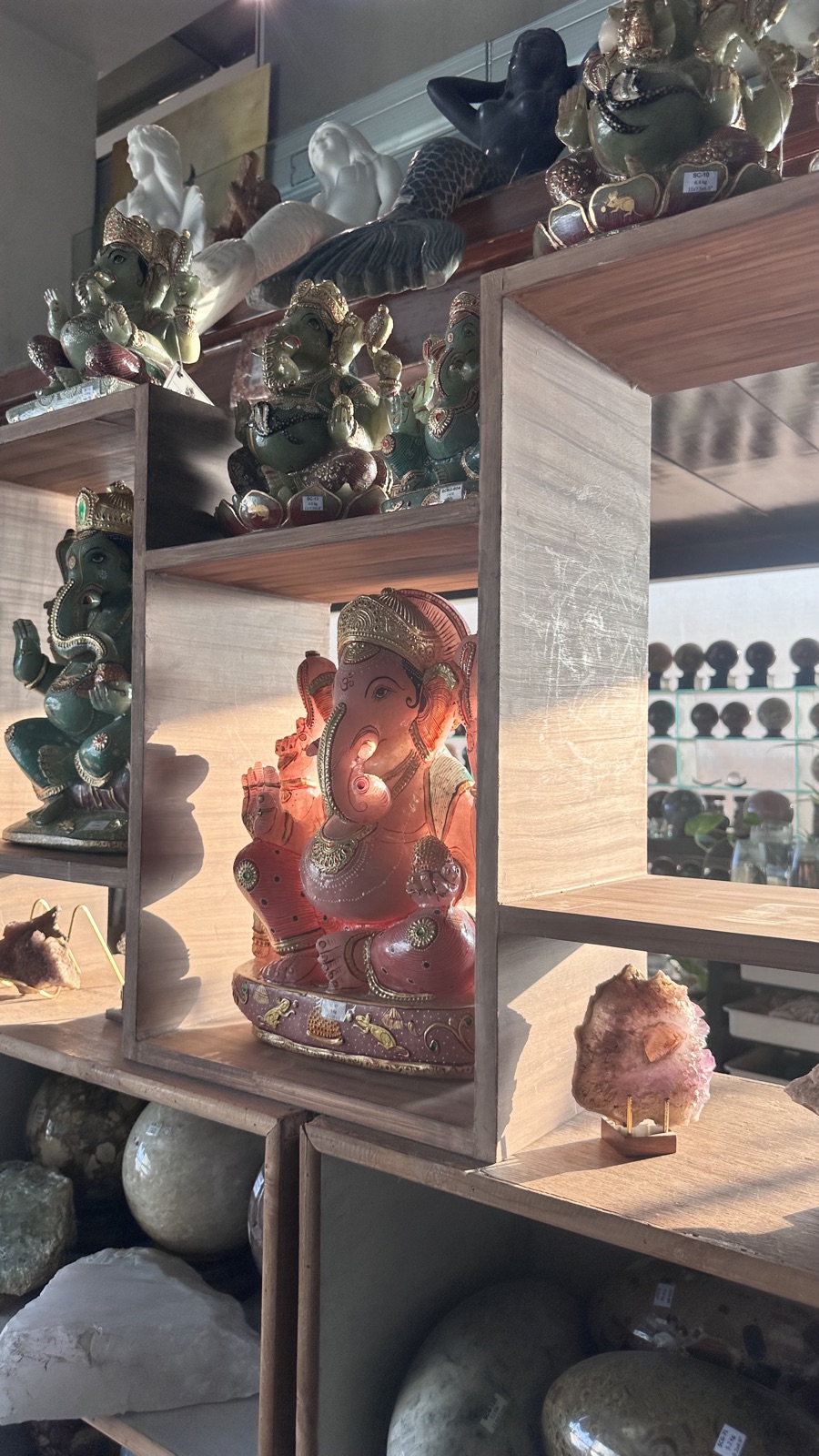 A carved Ganesha and gem sculptures on the atelier's cedar shelves